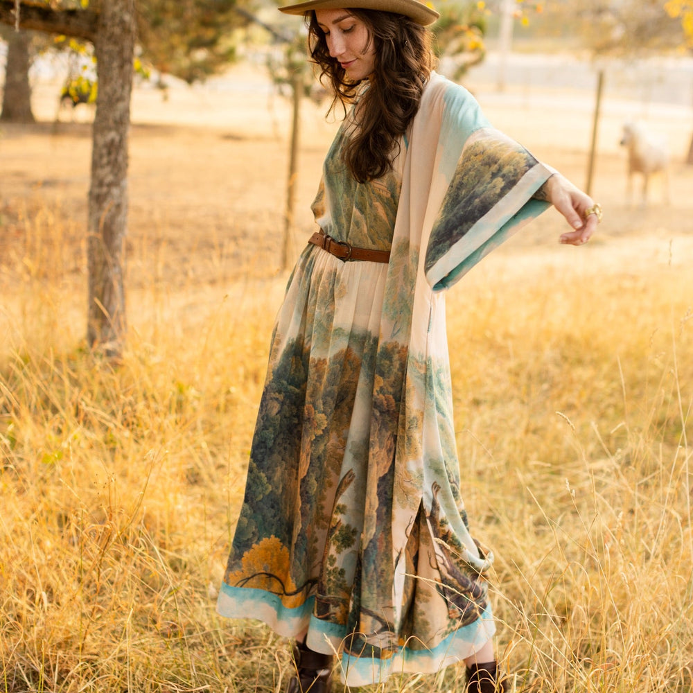 
                  
                    Soft bamboo viscose Bohéme slip dress featuring 18th-century Tivoli waterfalls and Lady Liberty artwork, designed to celebrate self-love and personal power – Market of Stars.
                  
                