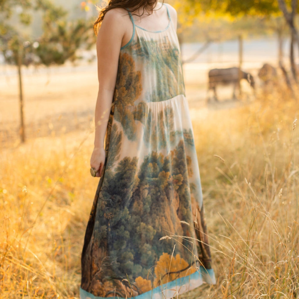 
                  
                    Soft bamboo viscose Bohéme slip dress featuring 18th-century Tivoli waterfalls and Lady Liberty artwork, designed to celebrate self-love and personal power – Market of Stars.
                  
                