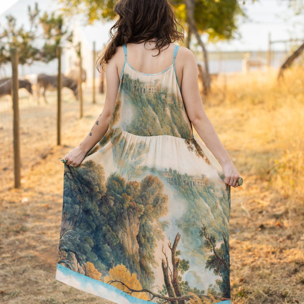 
                  
                    Soft bamboo viscose Bohéme slip dress featuring 18th-century Tivoli waterfalls and Lady Liberty artwork, designed to celebrate self-love and personal power – Market of Stars.
                  
                