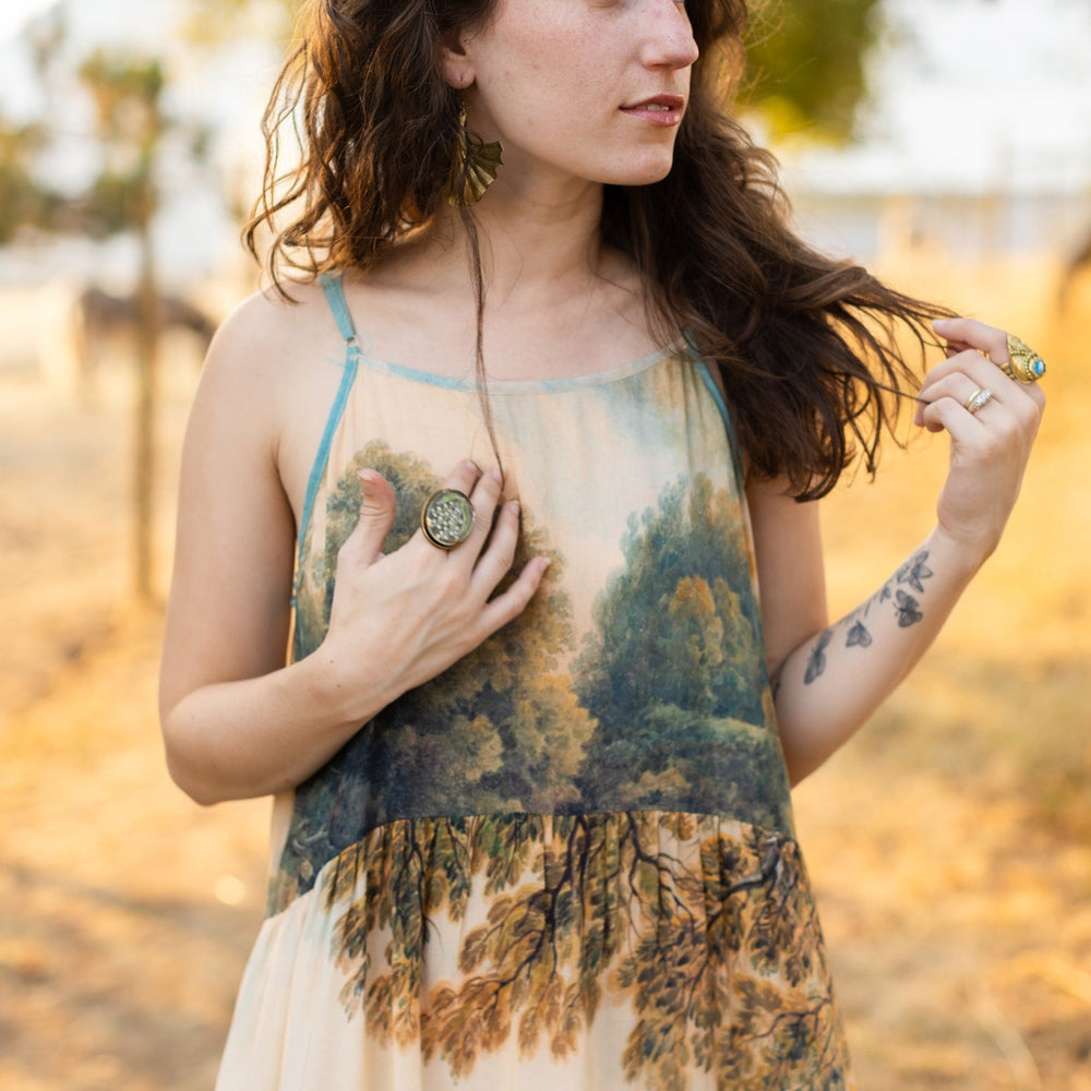 
                  
                    Soft bamboo viscose Bohéme slip dress featuring 18th-century Tivoli waterfalls and Lady Liberty artwork, designed to celebrate self-love and personal power – Market of Stars.
                  
                