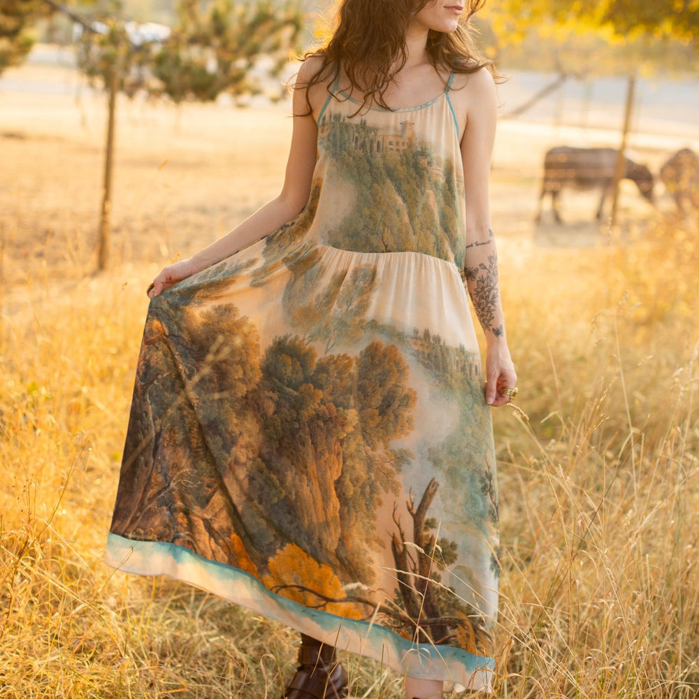 
                  
                    Soft bamboo viscose Bohéme slip dress featuring 18th-century Tivoli waterfalls and Lady Liberty artwork, designed to celebrate self-love and personal power – Market of Stars.
                  
                