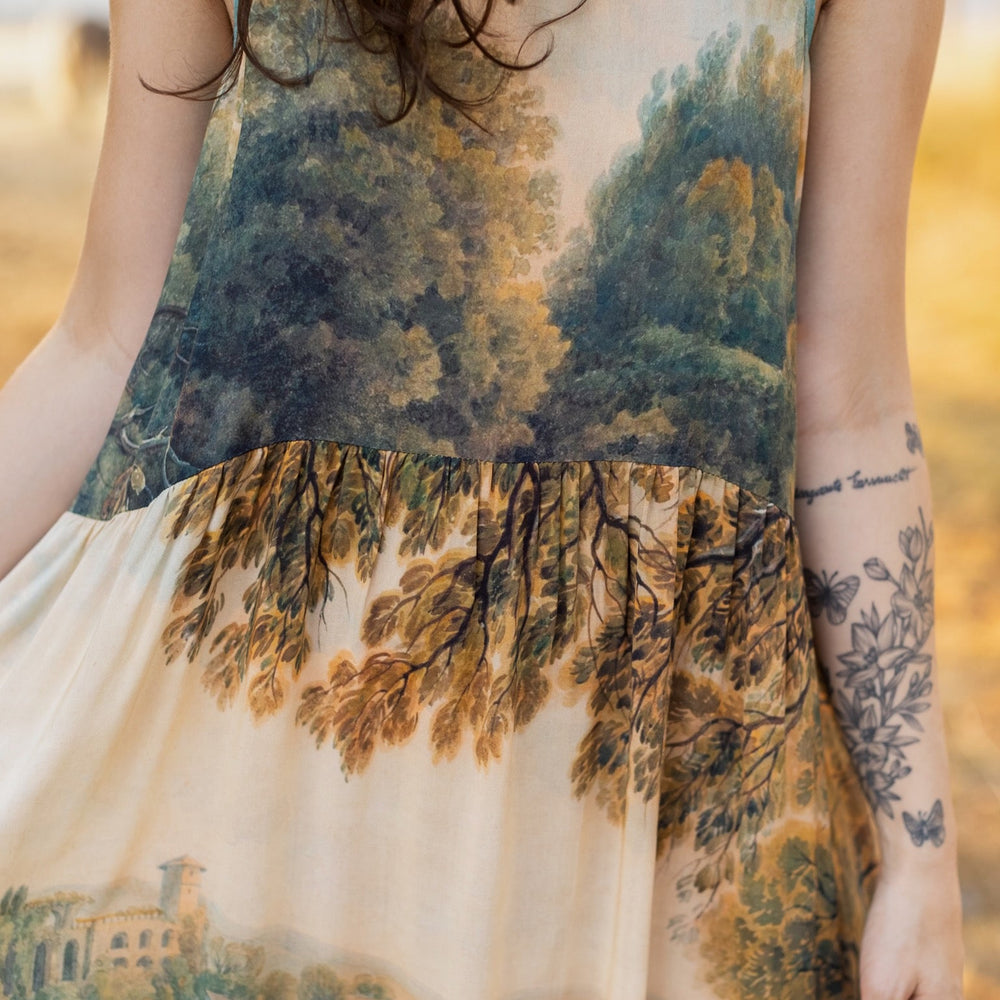 
                  
                    Soft bamboo viscose Bohéme slip dress featuring 18th-century Tivoli waterfalls and Lady Liberty artwork, designed to celebrate self-love and personal power – Market of Stars.
                  
                