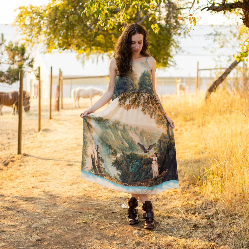 
                  
                    Soft bamboo viscose Bohéme slip dress featuring 18th-century Tivoli waterfalls and Lady Liberty artwork, designed to celebrate self-love and personal power – Market of Stars.
                  
                