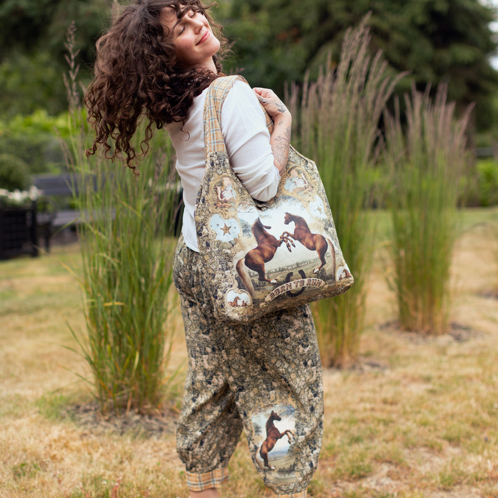 
                  
                    Model wearing a linen tote bag for everyday adventures with a whimsical print celebrating one's unbridled spirit of adventure - Market of Stars
                  
                