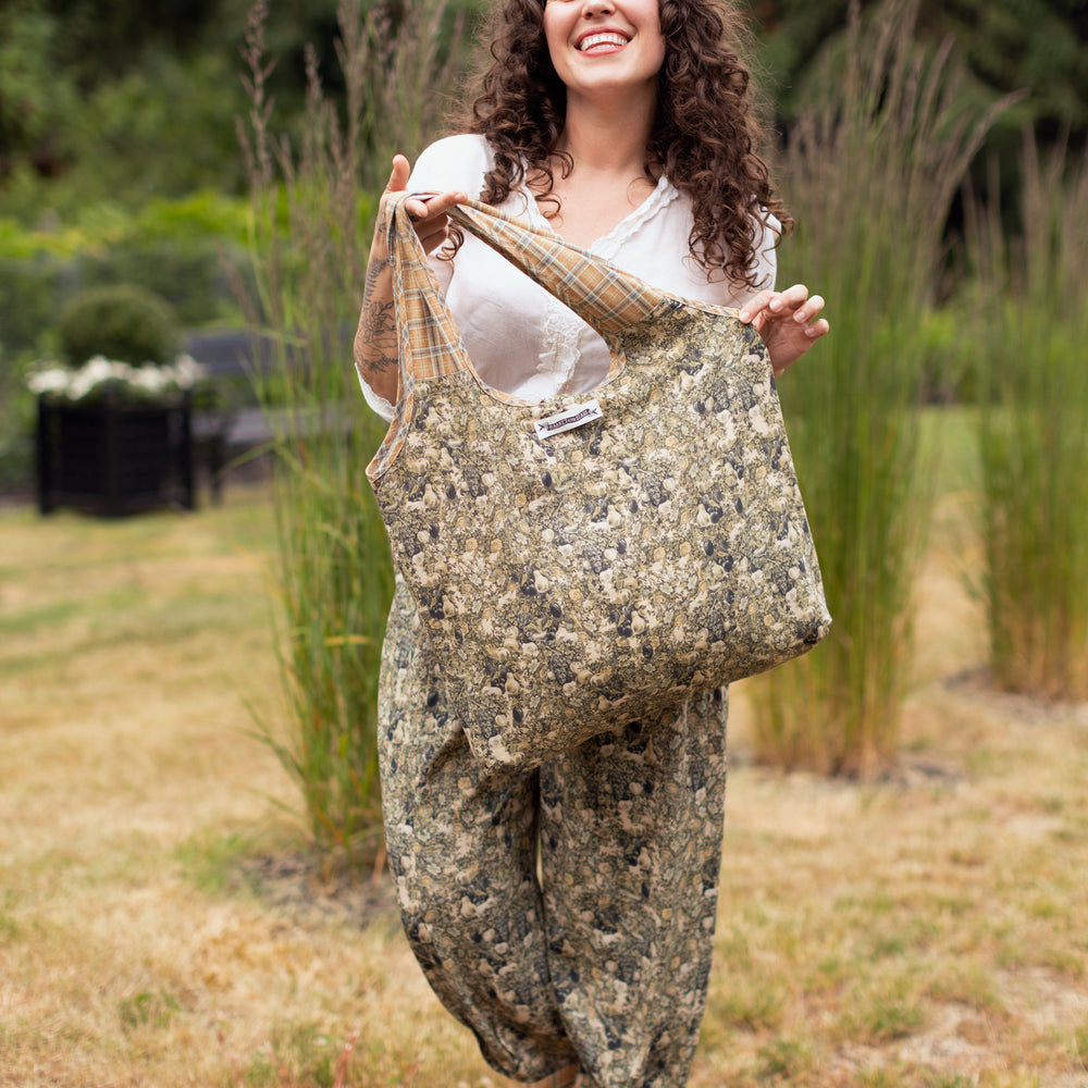 
                  
                    Model wearing a linen tote bag for everyday adventures with a whimsical print celebrating one's unbridled spirit of adventure - Market of Stars
                  
                