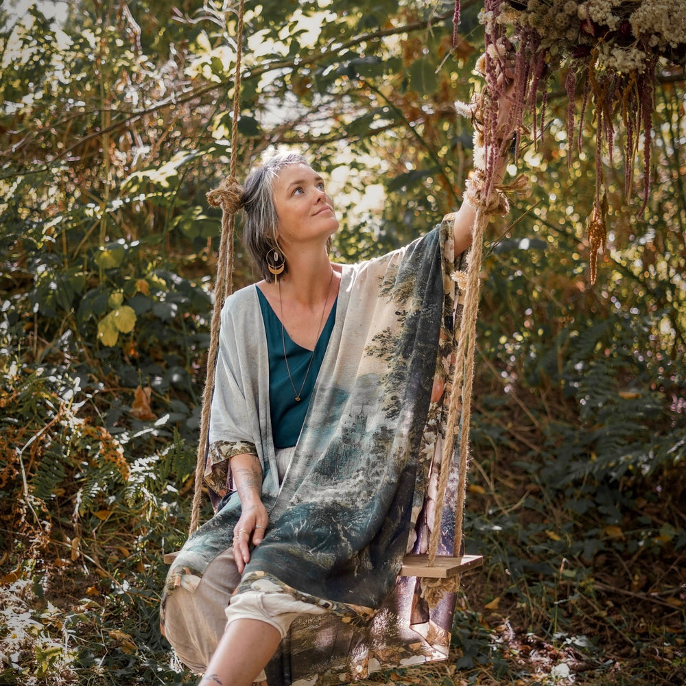 
                  
                    Castles in the Air Starduster kimono featuring Brueghel’s 1600s landscape, classical ruins, and joyful swing scene on bamboo-based viscose – Market of Stars.
                  
                