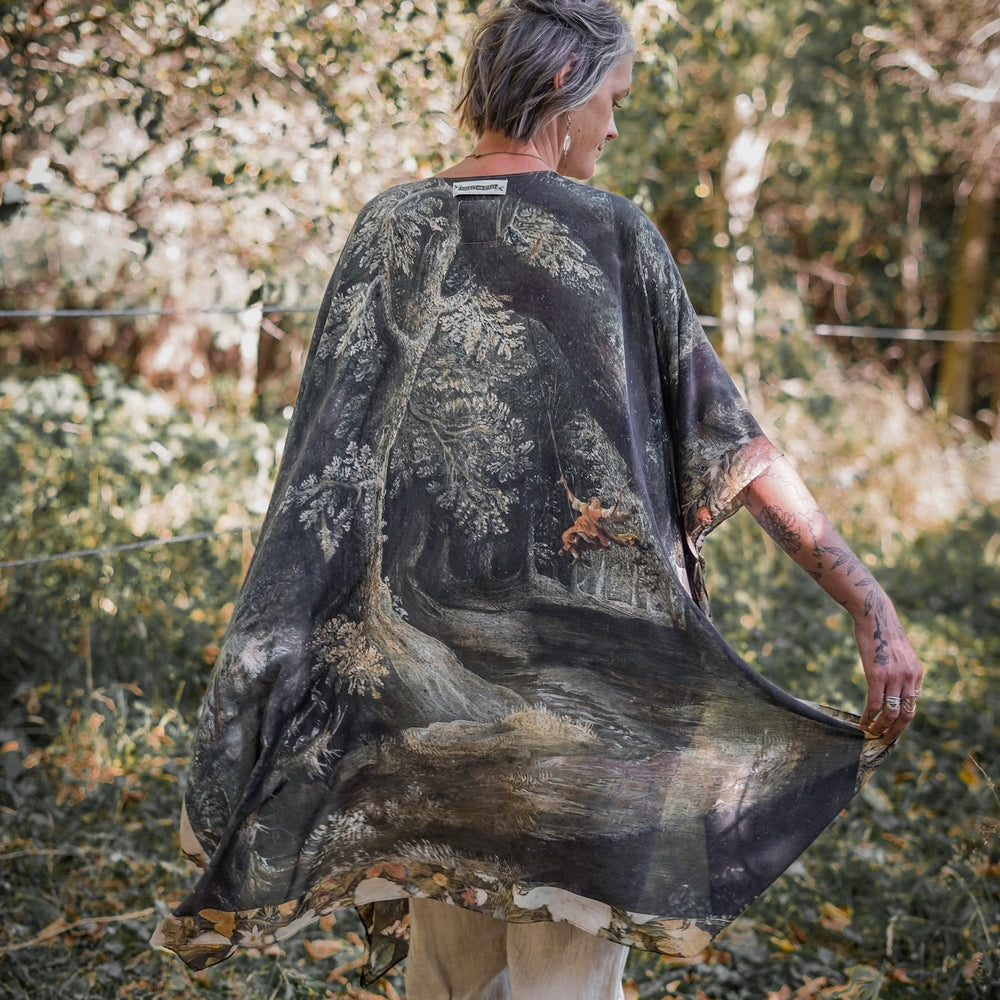 
                  
                    Castles in the Air Starduster kimono featuring Brueghel’s 1600s landscape, classical ruins, and joyful swing scene on bamboo-based viscose – Market of Stars.
                  
                