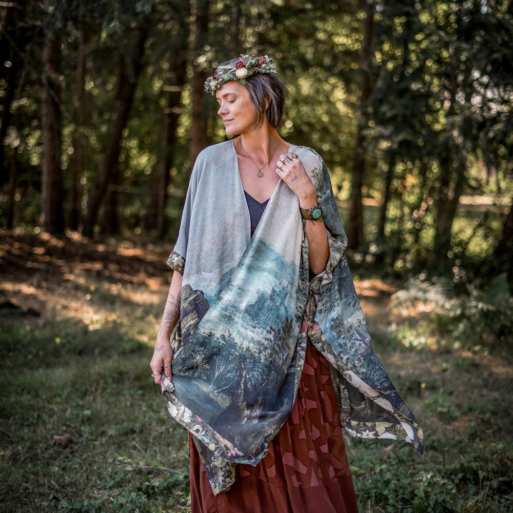 
                  
                    Castles in the Air Starduster kimono featuring Brueghel’s 1600s landscape, classical ruins, and joyful swing scene on bamboo-based viscose – Market of Stars.
                  
                