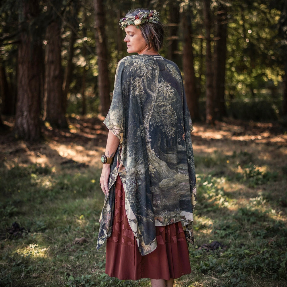
                  
                    Castles in the Air Starduster kimono featuring Brueghel’s 1600s landscape, classical ruins, and joyful swing scene on bamboo-based viscose – Market of Stars.
                  
                