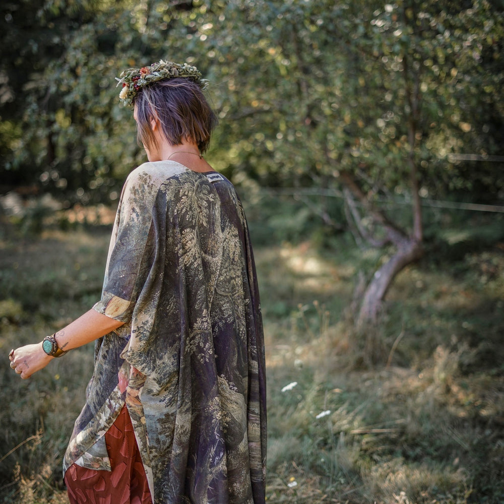 
                  
                    Castles in the Air Starduster kimono featuring Brueghel’s 1600s landscape, classical ruins, and joyful swing scene on bamboo-based viscose – Market of Stars.
                  
                