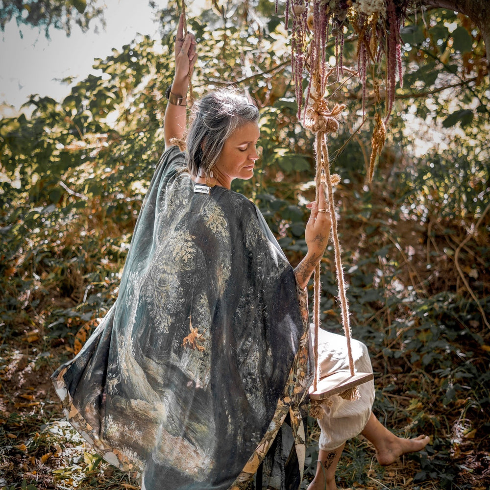 
                  
                    Castles in the Air Starduster kimono featuring Brueghel’s 1600s landscape, classical ruins, and joyful swing scene on bamboo-based viscose – Market of Stars.
                  
                