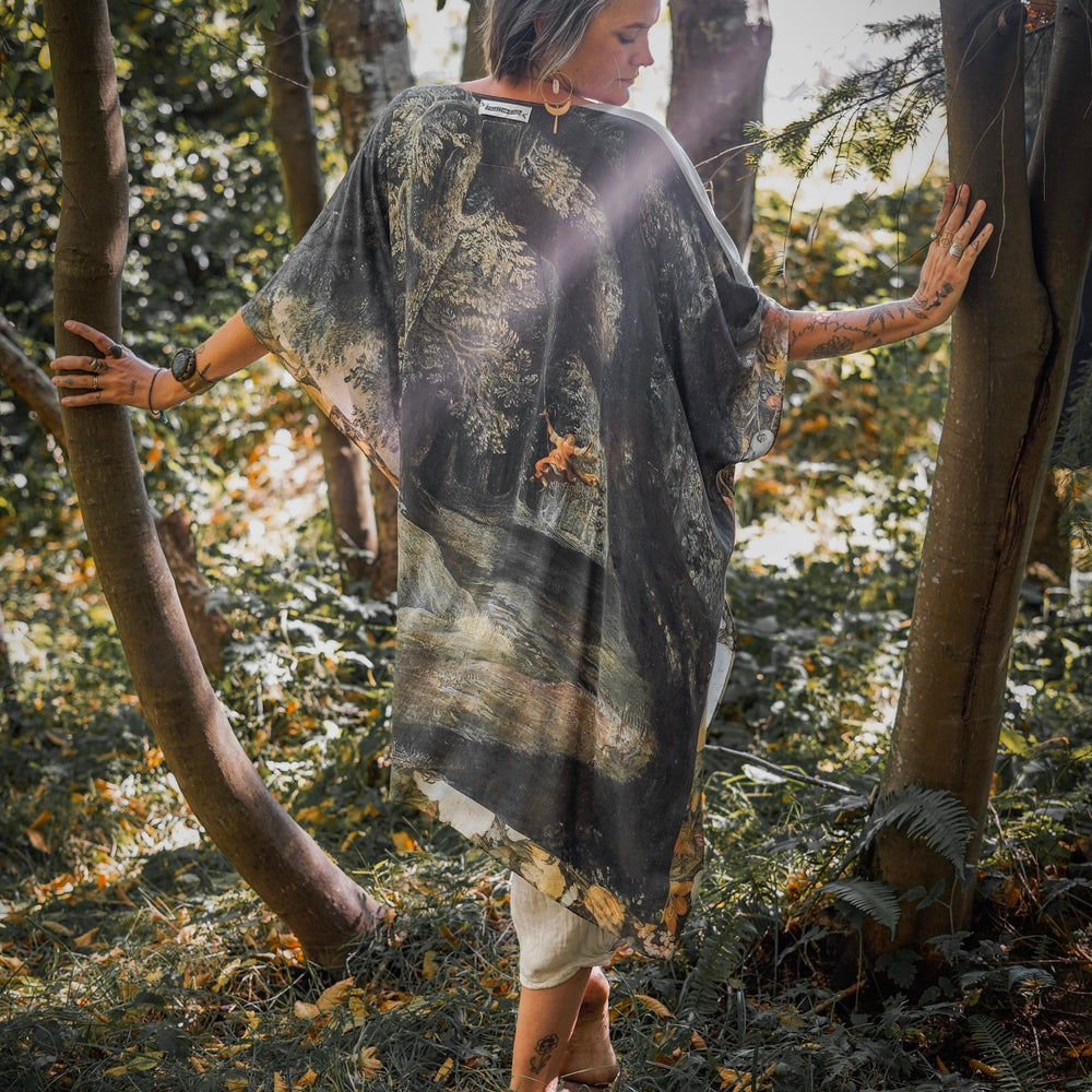 
                  
                    Castles in the Air Starduster kimono featuring Brueghel’s 1600s landscape, classical ruins, and joyful swing scene on bamboo-based viscose – Market of Stars.
                  
                