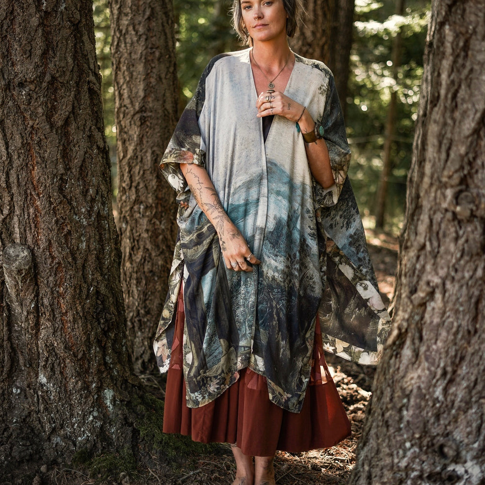 
                  
                    Castles in the Air Starduster kimono featuring Brueghel’s 1600s landscape, classical ruins, and joyful swing scene on bamboo-based viscose – Market of Stars.
                  
                