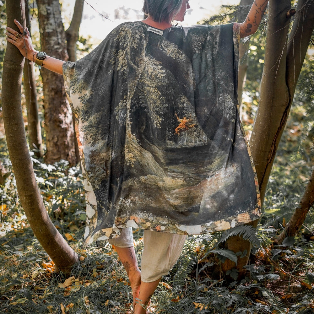 
                  
                    Castles in the Air Starduster kimono featuring Brueghel’s 1600s landscape, classical ruins, and joyful swing scene on bamboo-based viscose – Market of Stars.
                  
                