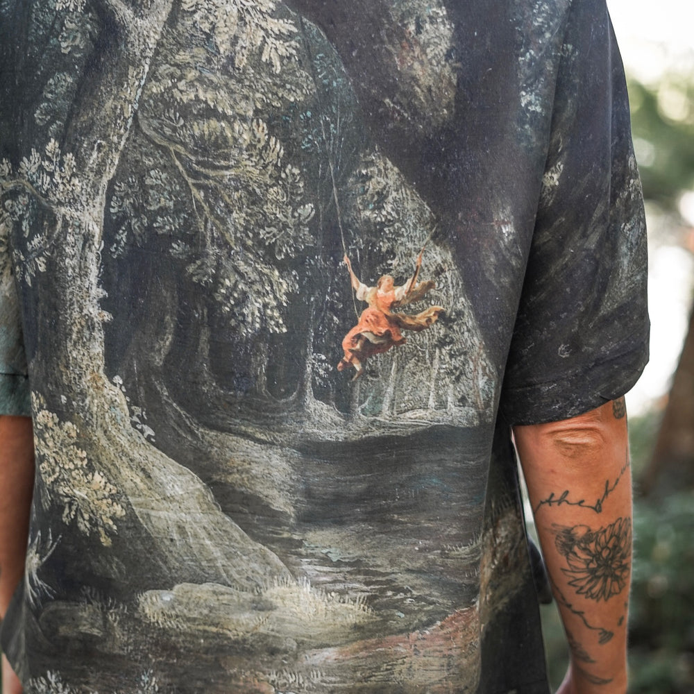 
                  
                    Castles in the Air Luxe Tee featuring Jan Brueghel’s whimsical 1600s landscape and painterly floral trim on soft bamboo-based viscose – Market of Stars.
                  
                