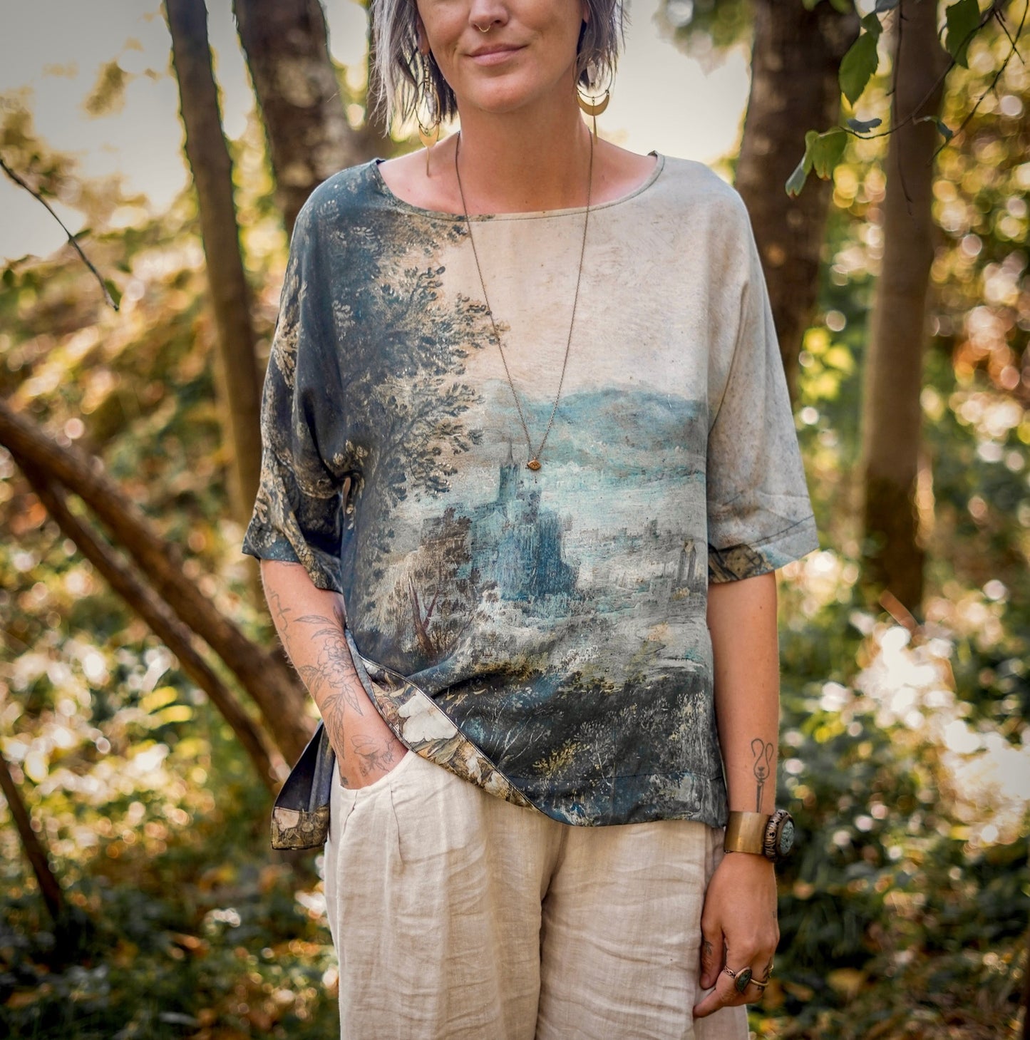 Castles in the Air Luxe Tee featuring Jan Brueghel’s whimsical 1600s landscape and painterly floral trim on soft bamboo-based viscose – Market of Stars.