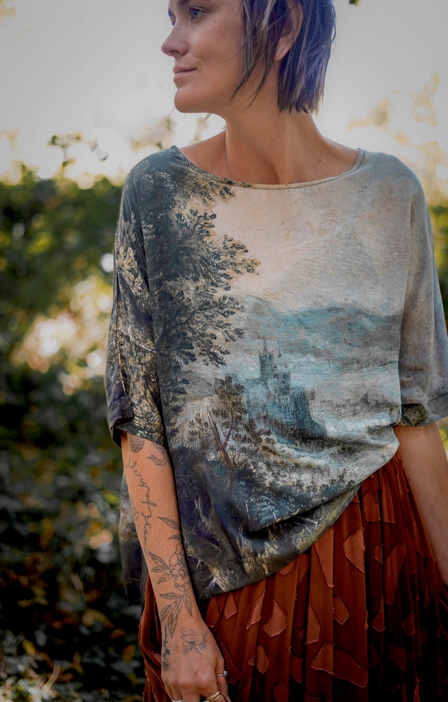Castles in the Air Luxe Tee featuring Jan Brueghel’s whimsical 1600s landscape and painterly floral trim on soft bamboo-based viscose – Market of Stars.