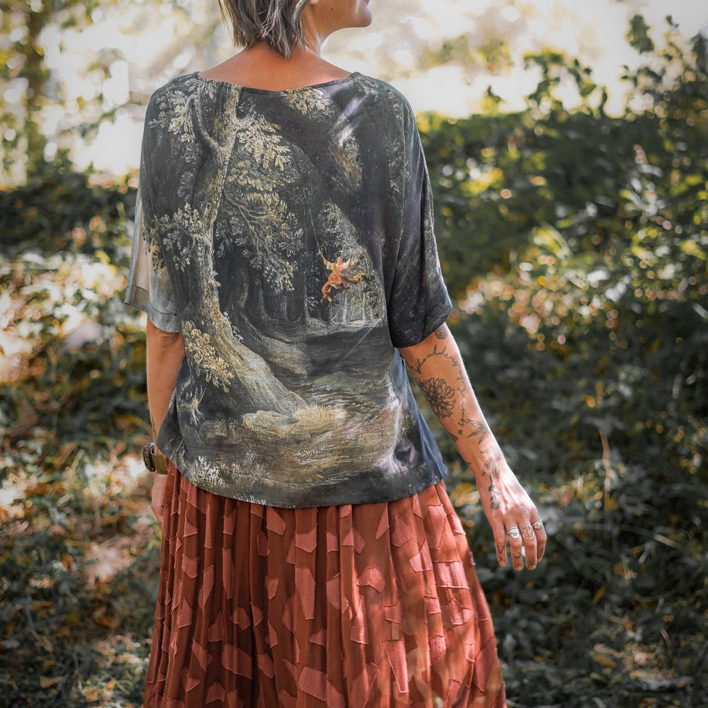 
                  
                    Castles in the Air Luxe Tee featuring Jan Brueghel’s whimsical 1600s landscape and painterly floral trim on soft bamboo-based viscose – Market of Stars.
                  
                