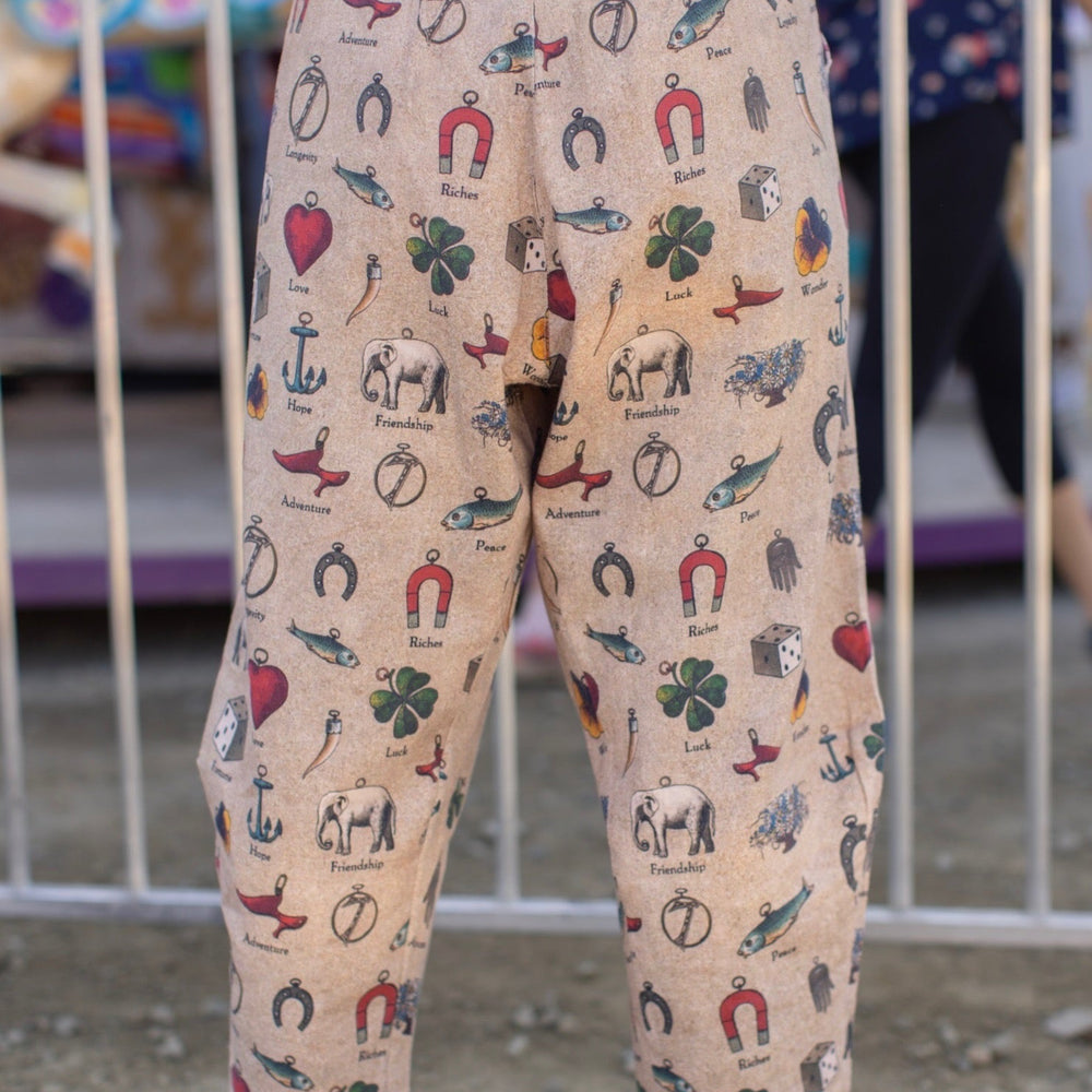 
                  
                    Charmed Life Artist Pants featuring playful Victorian luck charms and floral trim on breathable linen & bamboo/wood viscose – Market of Stars.
                  
                