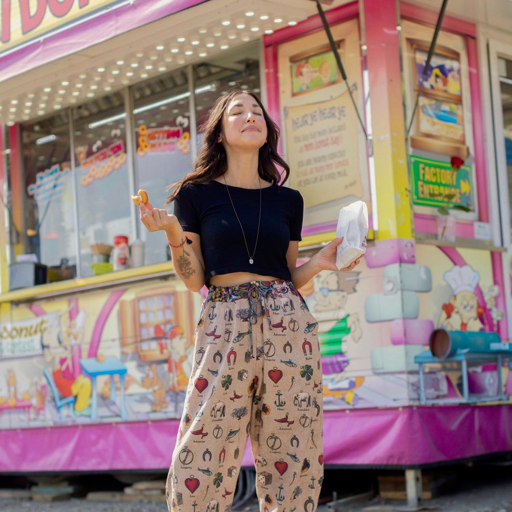 
                  
                    Charmed Life Artist Pants featuring playful Victorian luck charms and floral trim on breathable linen & bamboo/wood viscose – Market of Stars.
                  
                