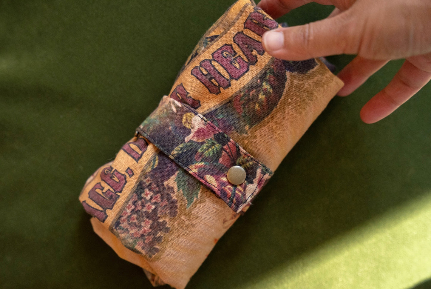 Model holding Take Heart Market Tote featuring Victorian lithographs, Sacred Heart artwork, and “courage, dear heart” script on linen blend fabric – Market of Stars.
