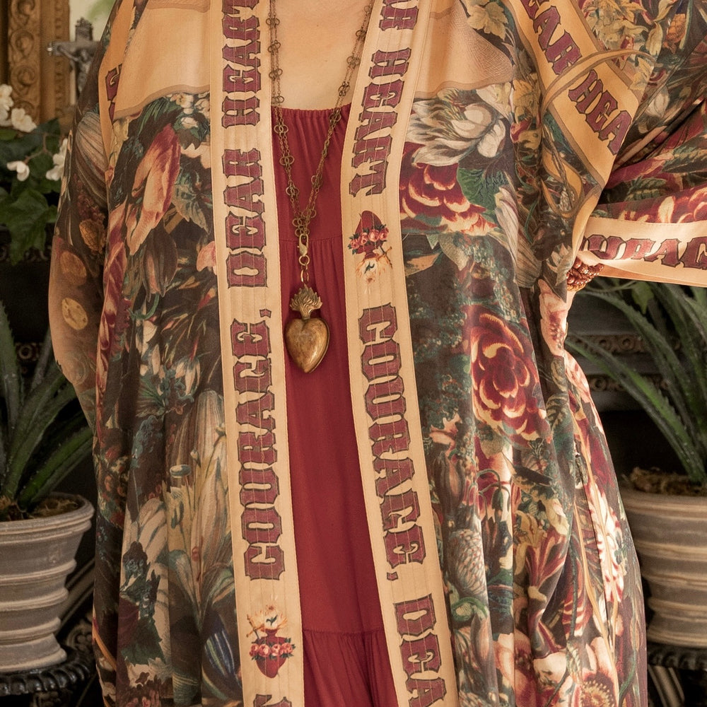 
                  
                    Model wearing Take Heart Opera Duster featuring Victorian Sacred Heart art, hidden affirmations of love, courage, and strength on bamboo-based viscose – Market of Stars
                  
                