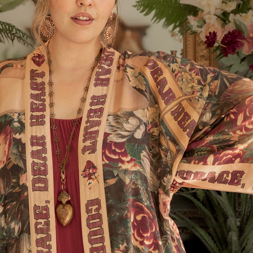 
                  
                    Model wearing Take Heart Opera Duster featuring Victorian Sacred Heart art, hidden affirmations of love, courage, and strength on bamboo-based viscose – Market of Stars
                  
                