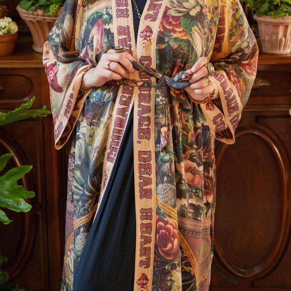 
                  
                    Model wearing Take Heart Opera Duster featuring Victorian Sacred Heart art, hidden affirmations of love, courage, and strength on bamboo-based viscose – Market of Stars
                  
                