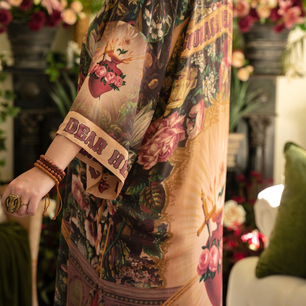 
                  
                    Model wearing Take Heart Opera Duster featuring Victorian Sacred Heart art, hidden affirmations of love, courage, and strength on bamboo-based viscose – Market of Stars
                  
                