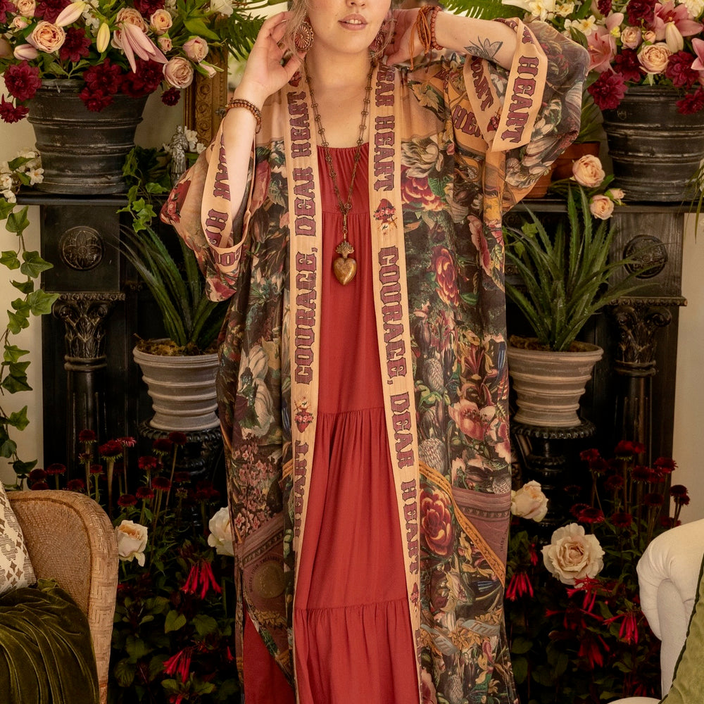 
                  
                    Model wearing Take Heart Opera Duster featuring Victorian Sacred Heart art, hidden affirmations of love, courage, and strength on bamboo-based viscose – Market of Stars
                  
                
