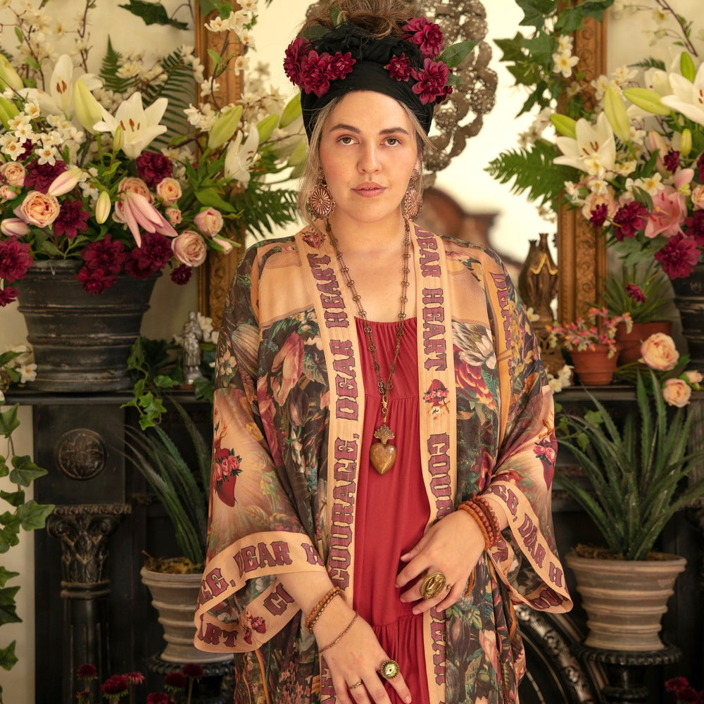 
                  
                    Model wearing Take Heart Opera Duster featuring Victorian Sacred Heart art, hidden affirmations of love, courage, and strength on bamboo-based viscose – Market of Stars
                  
                