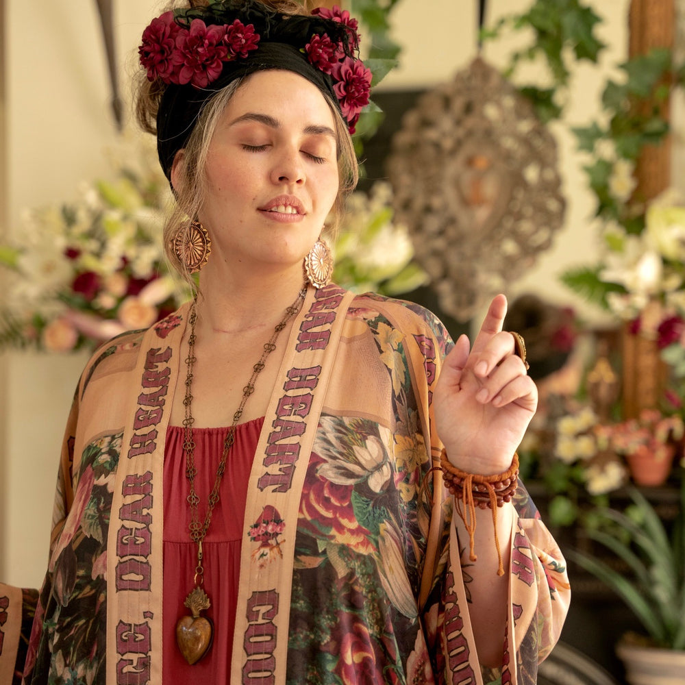 
                  
                    Model wearing Take Heart Opera Duster featuring Victorian Sacred Heart art, hidden affirmations of love, courage, and strength on bamboo-based viscose – Market of Stars
                  
                