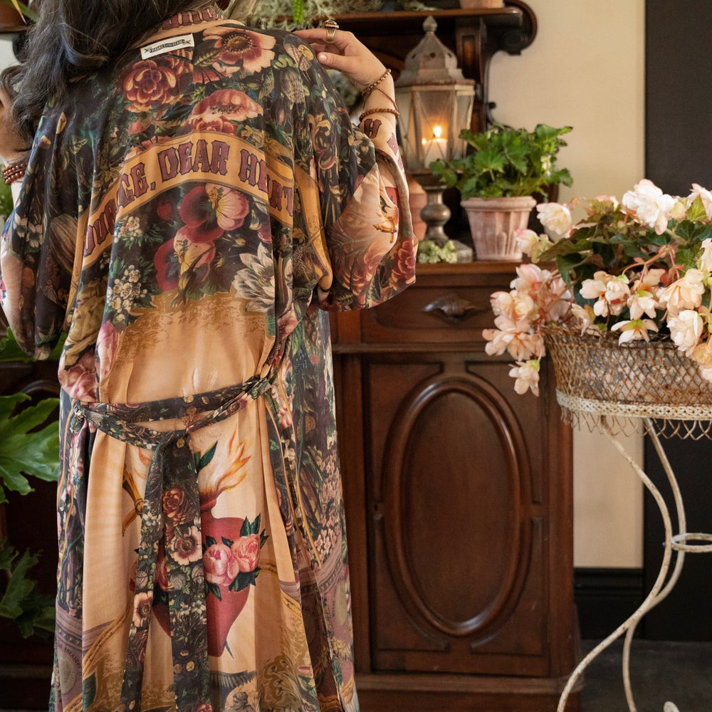 
                  
                    Model wearing Take Heart Opera Duster featuring Victorian Sacred Heart art, hidden affirmations of love, courage, and strength on bamboo-based viscose – Market of Stars
                  
                