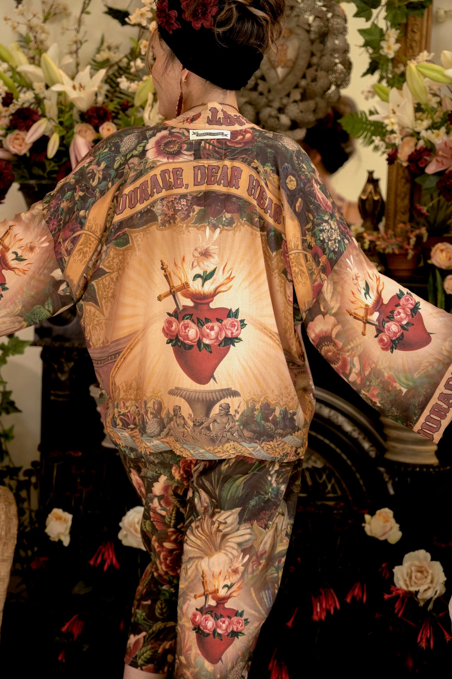 Model wearing Courage Dear Heart Pixie cut Duster featuring Victorian Sacred Heart art and hidden affirmations of courage and love on bamboo-based viscose – Market of Stars.