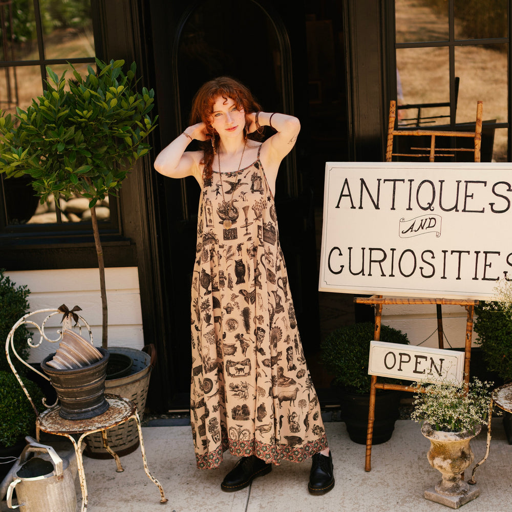 
                  
                    Model wearing a maxi-length bamboo viscose slip dress inspired by a mysterious Victorian scrapbook. This whimsical print celebrates the wonder hidden in ordinary things — Market of Stars.
                  
                