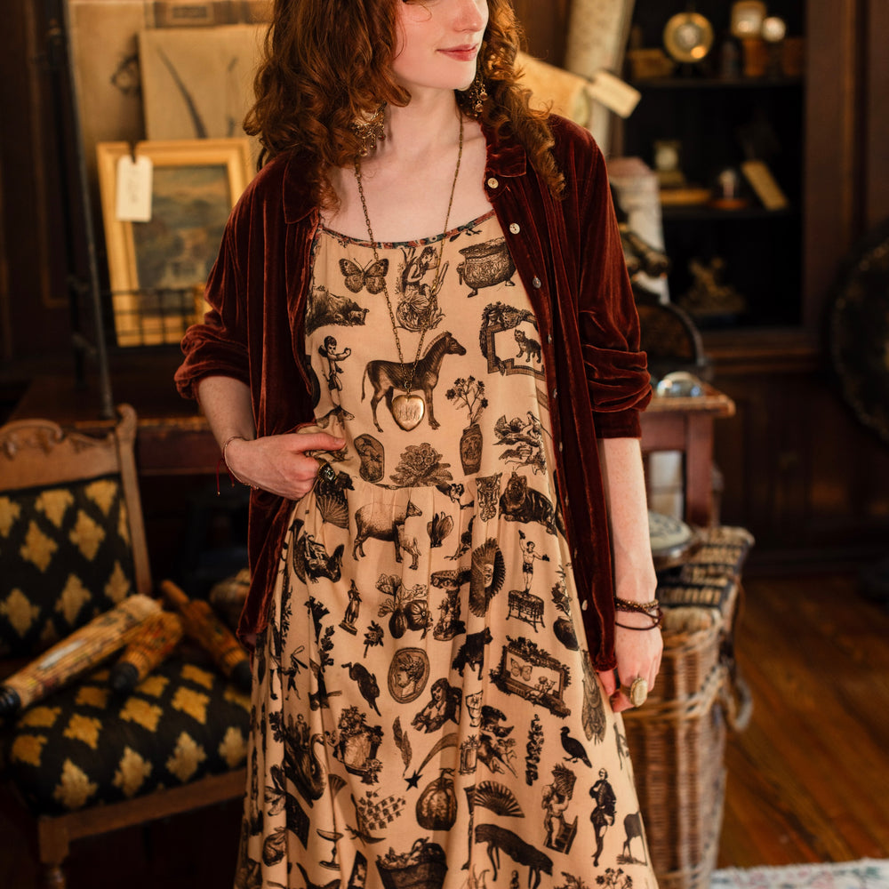 
                  
                    Model wearing a maxi-length bamboo viscose slip dress inspired by a mysterious Victorian scrapbook. This whimsical print celebrates the wonder hidden in ordinary things — Market of Stars.
                  
                