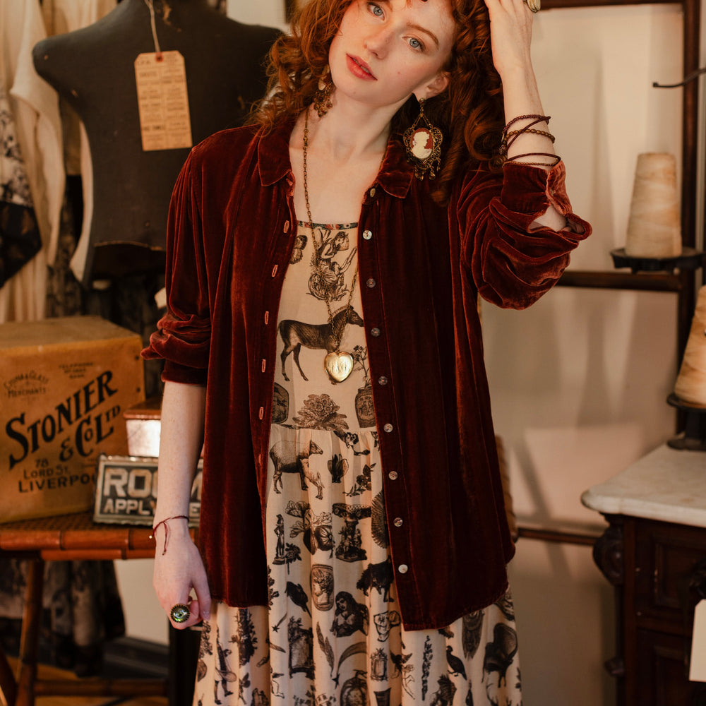 
                  
                    Model wearing a maxi-length bamboo viscose slip dress inspired by a mysterious Victorian scrapbook. This whimsical print celebrates the wonder hidden in ordinary things — Market of Stars.
                  
                