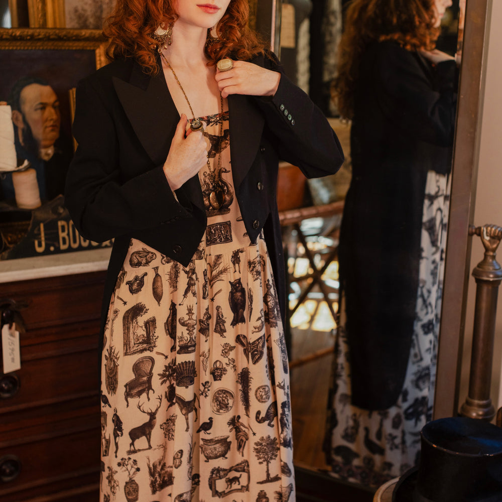 
                  
                    Model wearing a maxi-length bamboo viscose slip dress inspired by a mysterious Victorian scrapbook. This whimsical print celebrates the wonder hidden in ordinary things — Market of Stars.
                  
                