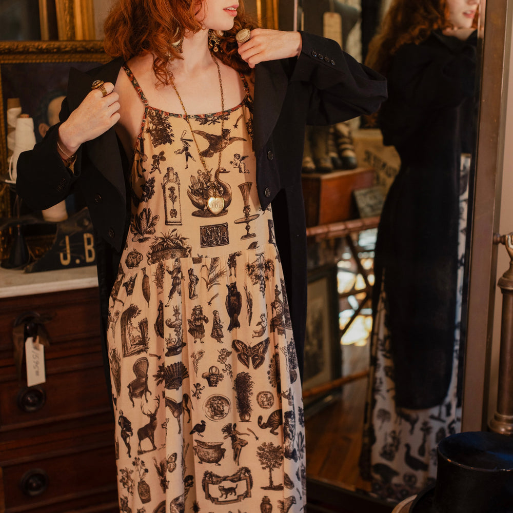 
                  
                    Model wearing a maxi-length bamboo viscose slip dress inspired by a mysterious Victorian scrapbook. This whimsical print celebrates the wonder hidden in ordinary things — Market of Stars.
                  
                