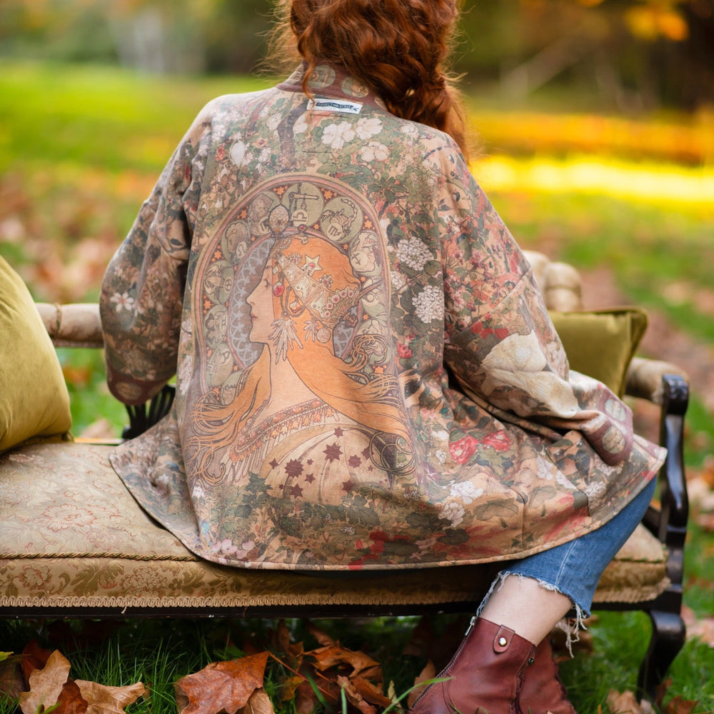 Model wearing Dreamweaver Cottage Cardigan featuring Mucha’s 1896 zodiac woman with celestial crown, printed on cozy fleece-lined cotton blend – Market of Stars