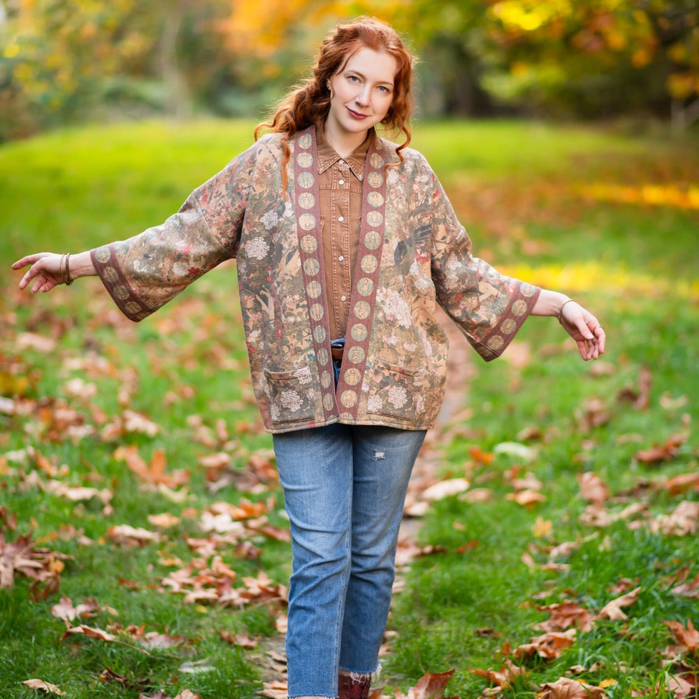 
                  
                    Model wearing Dreamweaver Cottage Cardigan featuring Mucha’s 1896 zodiac woman with celestial crown, printed on cozy fleece-lined cotton blend – Market of Stars
                  
                