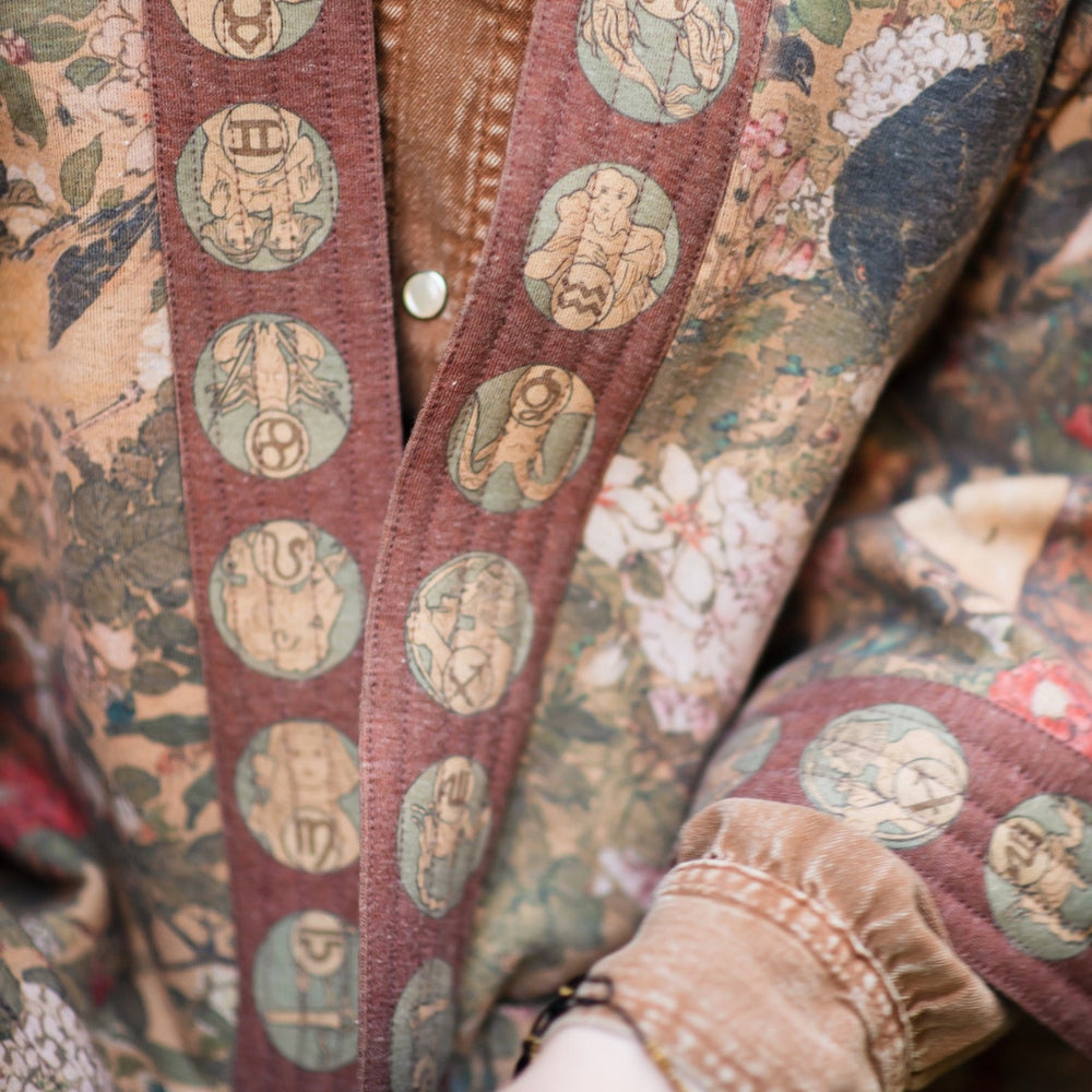 
                  
                    Model wearing Dreamweaver Cottage Cardigan featuring Mucha’s 1896 zodiac woman with celestial crown, printed on cozy fleece-lined cotton blend – Market of Stars
                  
                