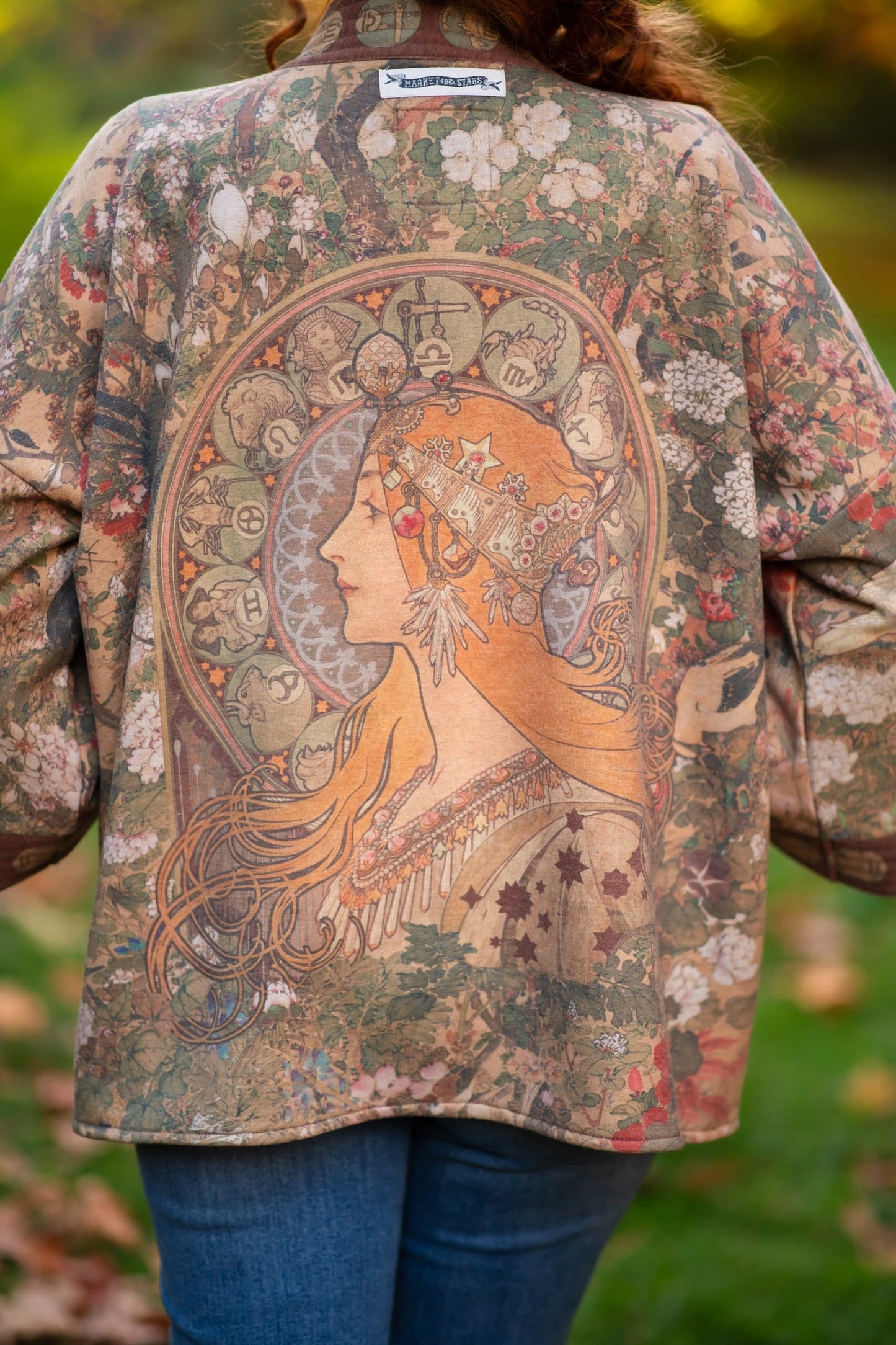 Model wearing Dreamweaver Cottage Cardigan featuring Mucha’s 1896 zodiac woman with celestial crown, printed on cozy fleece-lined cotton blend – Market of Stars