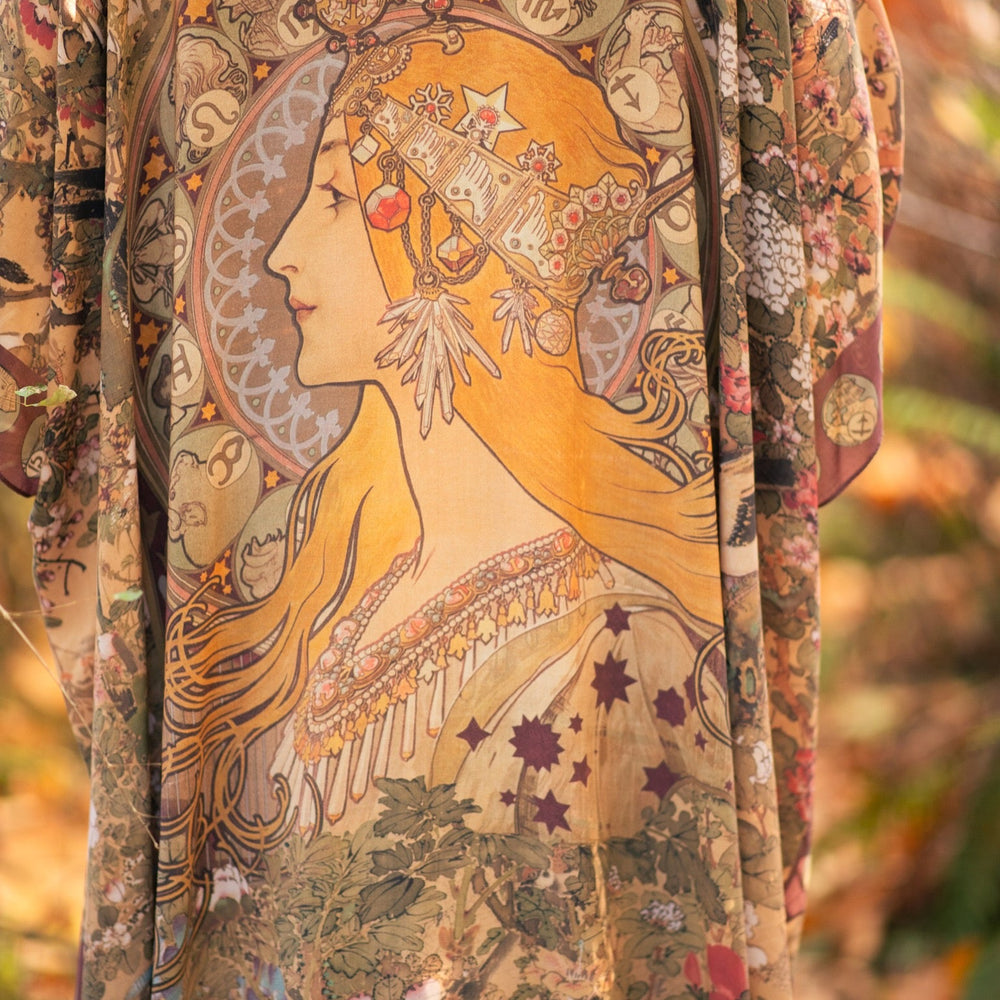 
                  
                    Dreamweaver Goddess Duster featuring Alphonse Mucha’s 1896 zodiac woman, celestial crown, and burgundy zodiac trim inspired by vintage bohemian style – Market of Stars
                  
                