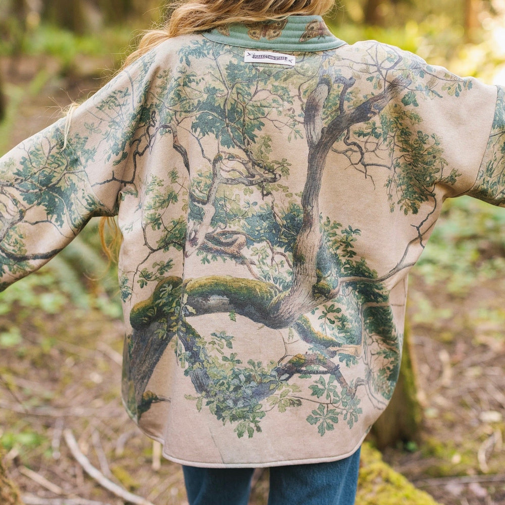 Model wearing Earth and Sky Cottage Jacket – featuring Charles Aston’s tree painting and antique moth art – cozy fleece-lined cardigan for cooler days – Market of Stars.