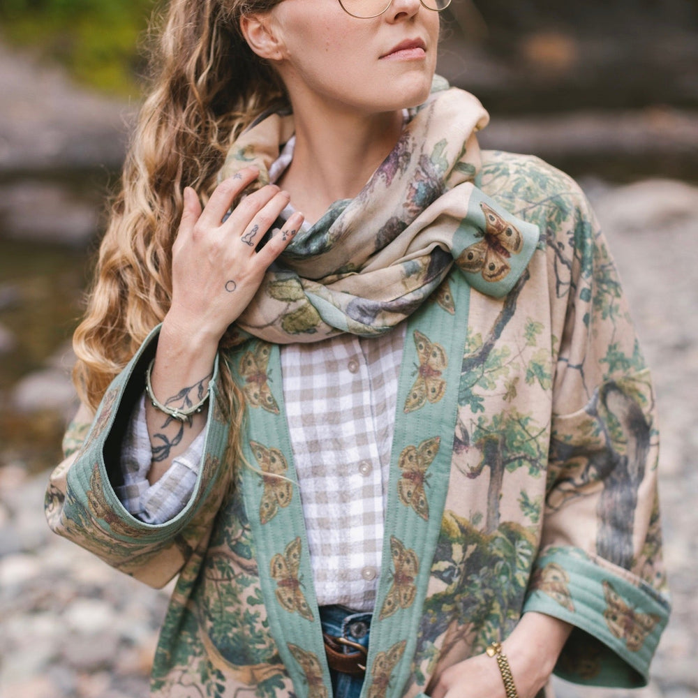 
                  
                    Model wearing Earth and Sky Cottage Jacket – featuring Charles Aston’s tree painting and antique moth art – cozy fleece-lined cardigan for cooler days – Market of Stars.
                  
                