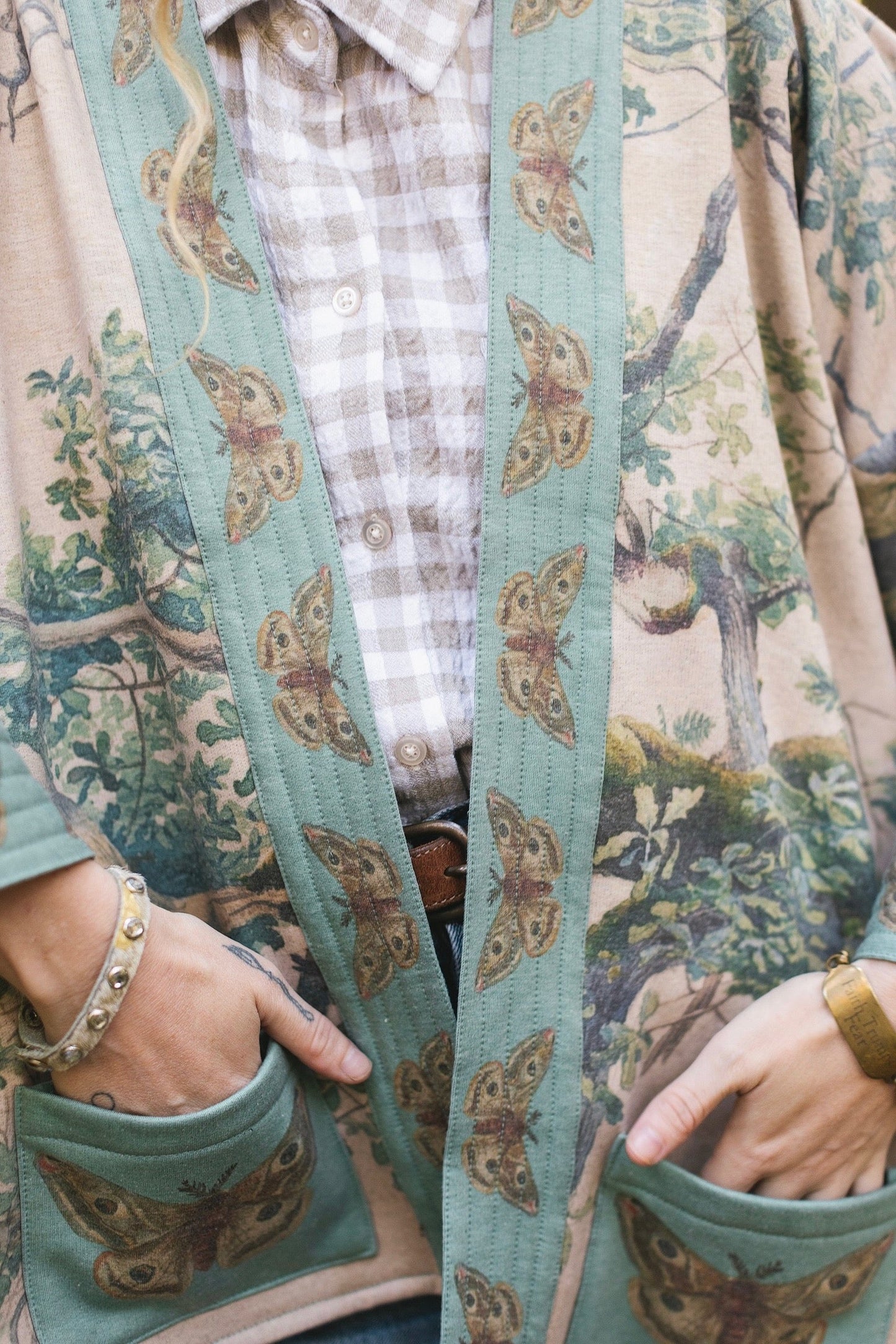 Model wearing Earth and Sky Cottage Jacket – featuring Charles Aston’s tree painting and antique moth art – cozy fleece-lined cardigan for cooler days – Market of Stars.