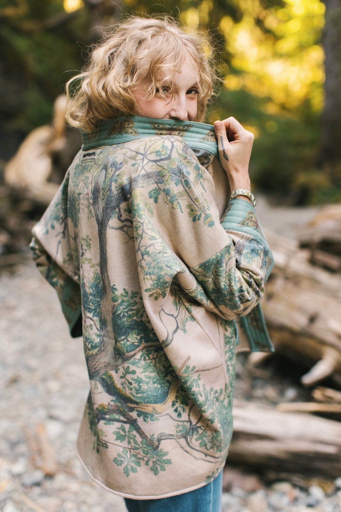Model wearing Earth and Sky Cottage Jacket – featuring Charles Aston’s tree painting and antique moth art – cozy fleece-lined cardigan for cooler days – Market of Stars.