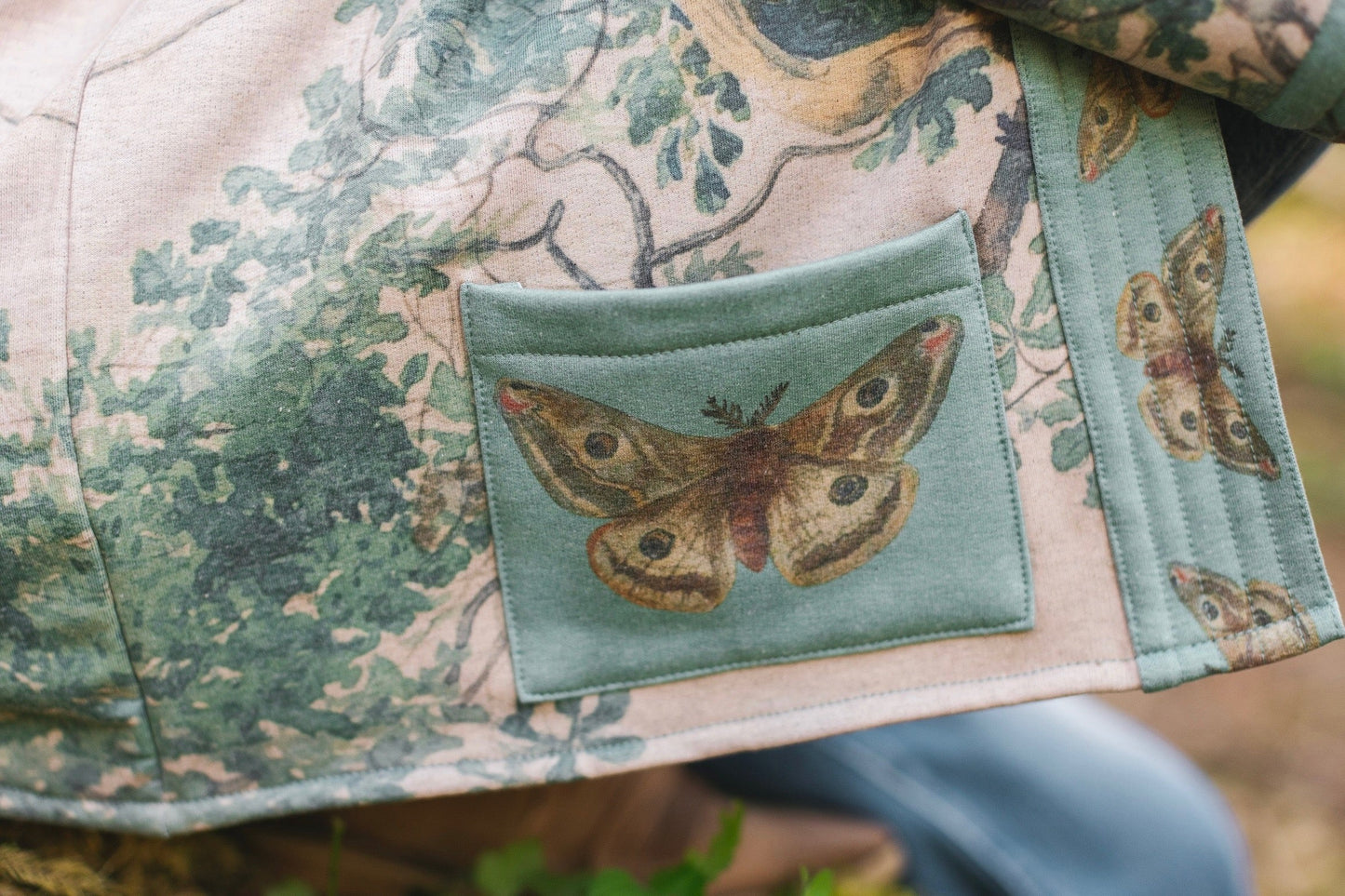 Model wearing Earth and Sky Cottage Jacket – featuring Charles Aston’s tree painting and antique moth art – cozy fleece-lined cardigan for cooler days – Market of Stars.
