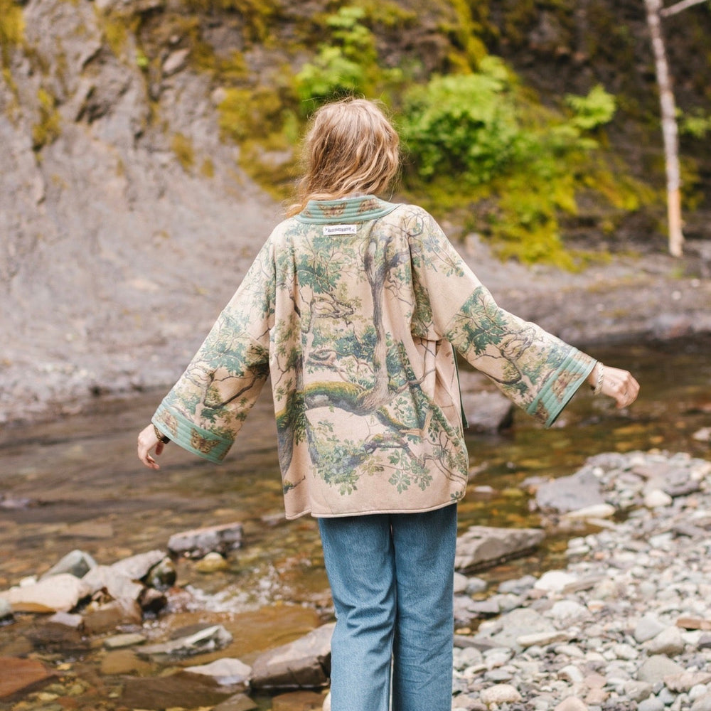 
                  
                    Model wearing Earth and Sky Cottage Jacket – featuring Charles Aston’s tree painting and antique moth art – cozy fleece-lined cardigan for cooler days – Market of Stars.
                  
                
